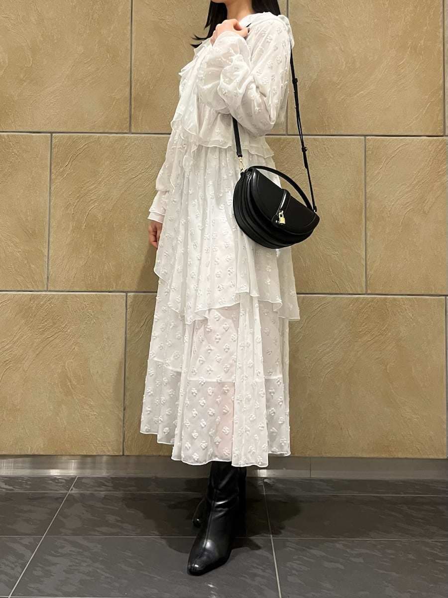 ブラック系のブーツ、ブラック系のハンドバッグ、シルバー系のスカートを着用したレディースの冬コーディネートの3枚目の写真