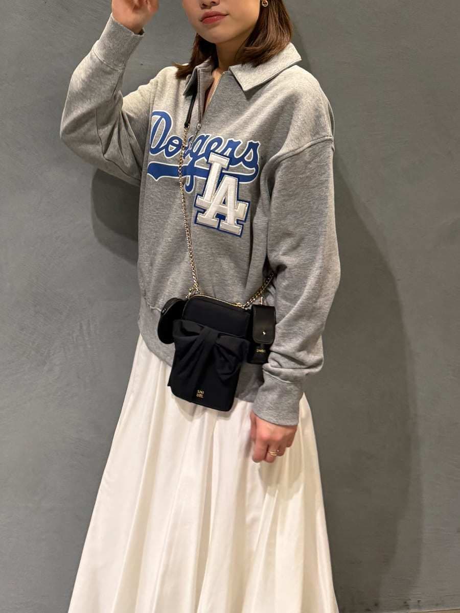 グレー系のスウェット、ブラック系のショルダーバッグ、ホワイト系のスカートを着用したレディースの春コーディネートの9枚目の写真