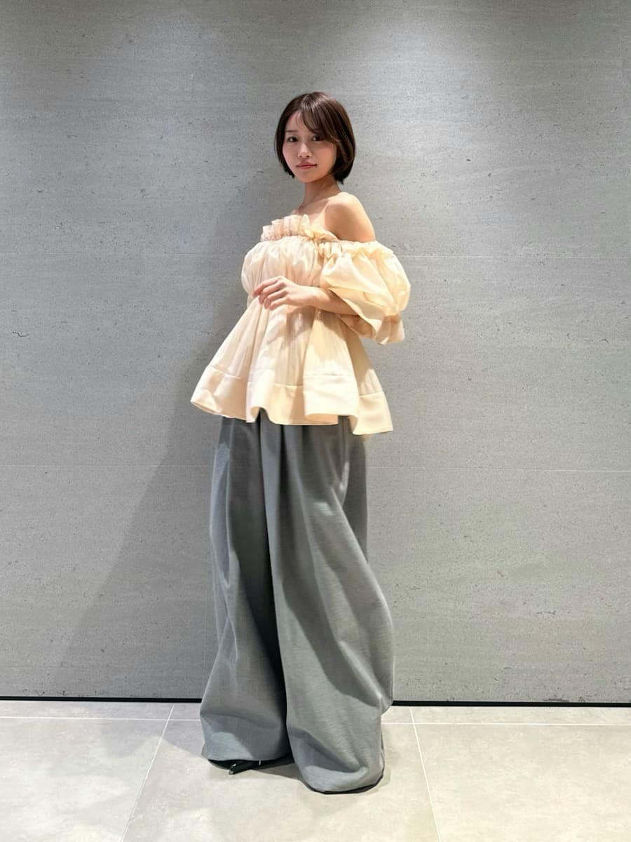 グレー系のデニムパンツ、オレンジ系のその他トップス、ブラック系のパンプスを着用したレディースの春コーディネートの3枚目の写真