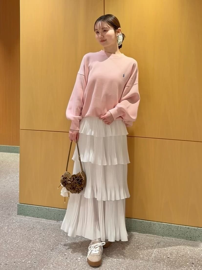 ホワイト系のスカート、ピンク系のスウェット、ブラウン系のハンドバッグを着用したレディースの春コーディネートの2枚目の写真