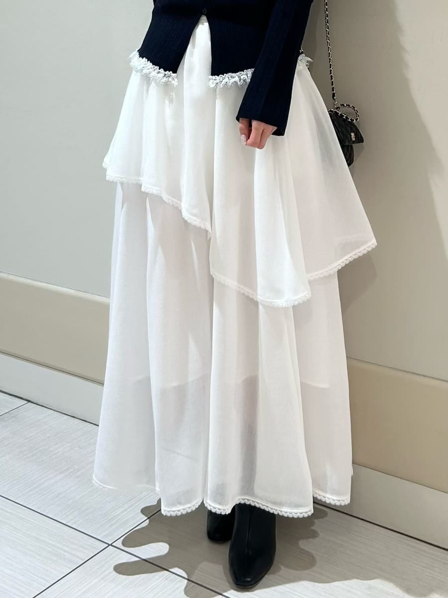 ブラック系のブーツ、ブラック系のショルダーバッグ、ホワイト系のスカートを着用したレディースの冬コーディネートの4枚目の写真