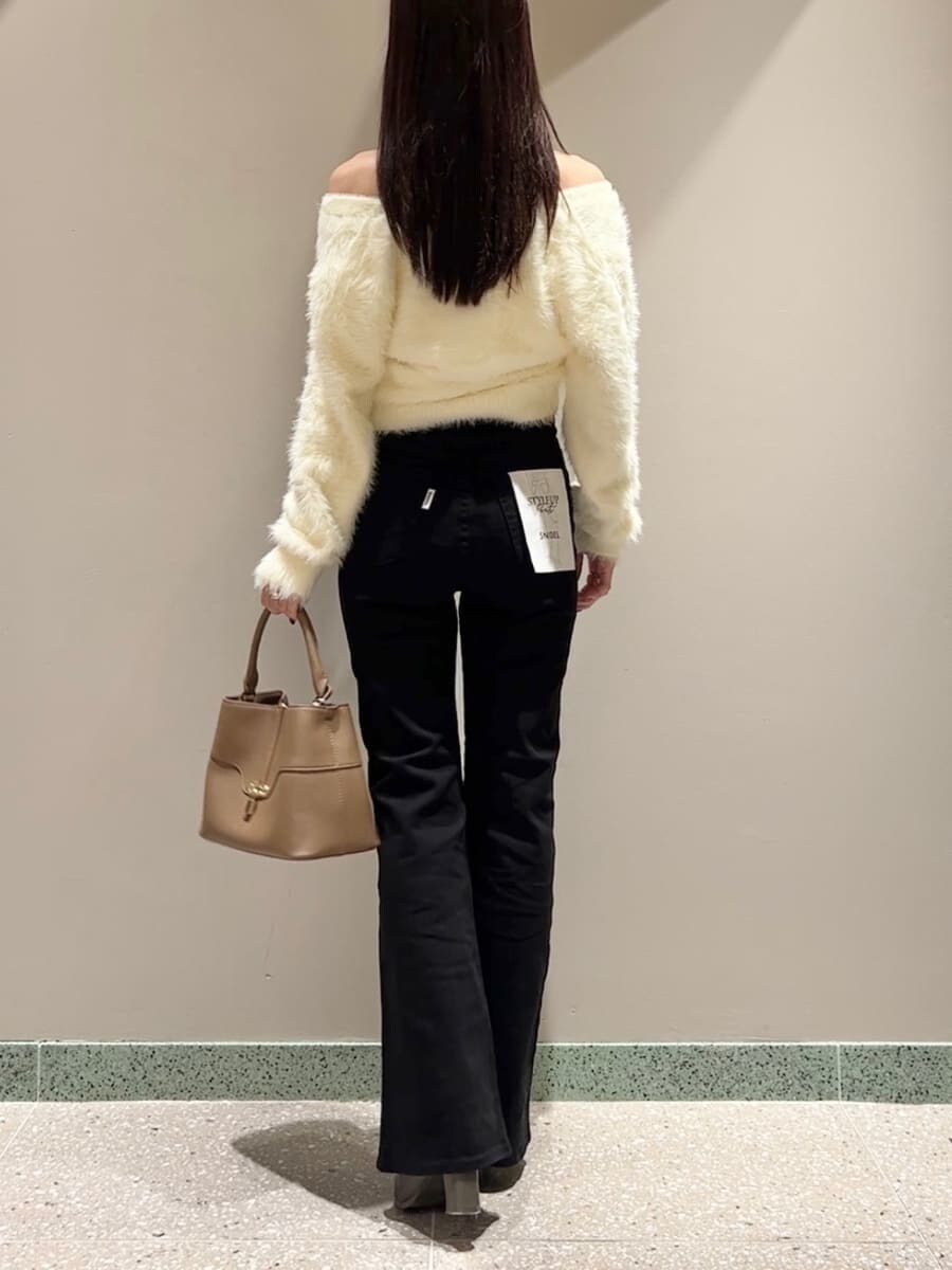 イエロー系のニット/セーター、ブラック系のその他パンツ、イエロー系のハンドバッグを着用したレディースの秋コーディネートの3枚目の写真