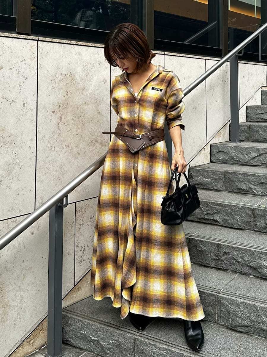 ブラック系のボストンバッグ、ホワイト系のピアス（両耳用）、ブラウン系のベルトを着用したレディースの冬コーディネートの4枚目の写真