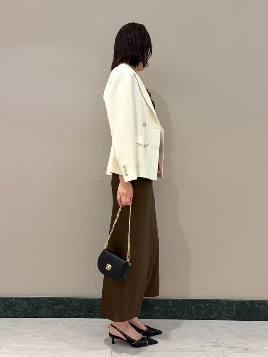 ホワイト系のテーラードジャケット、ブラック系のパンプス、ブラック系のショルダーバッグを着用したレディースの春コーディネートの6枚目の写真