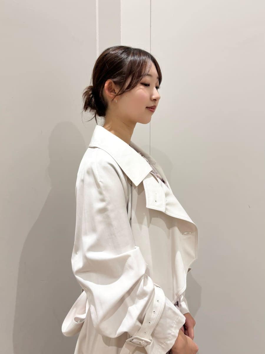 ホワイト系のトレンチコート、ピンク系のワンピース、ブラック系のパンプスを着用したレディースの冬コーディネートの5枚目の写真