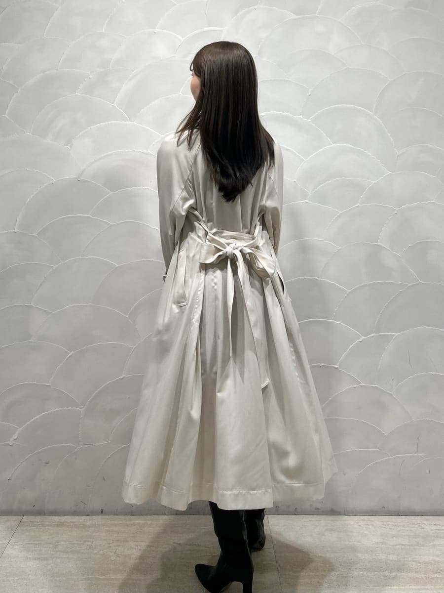 ブラック系のブーツ、ホワイト系のトレンチコート、グレー系のワンピースを着用したレディースの冬コーディネートの3枚目の写真