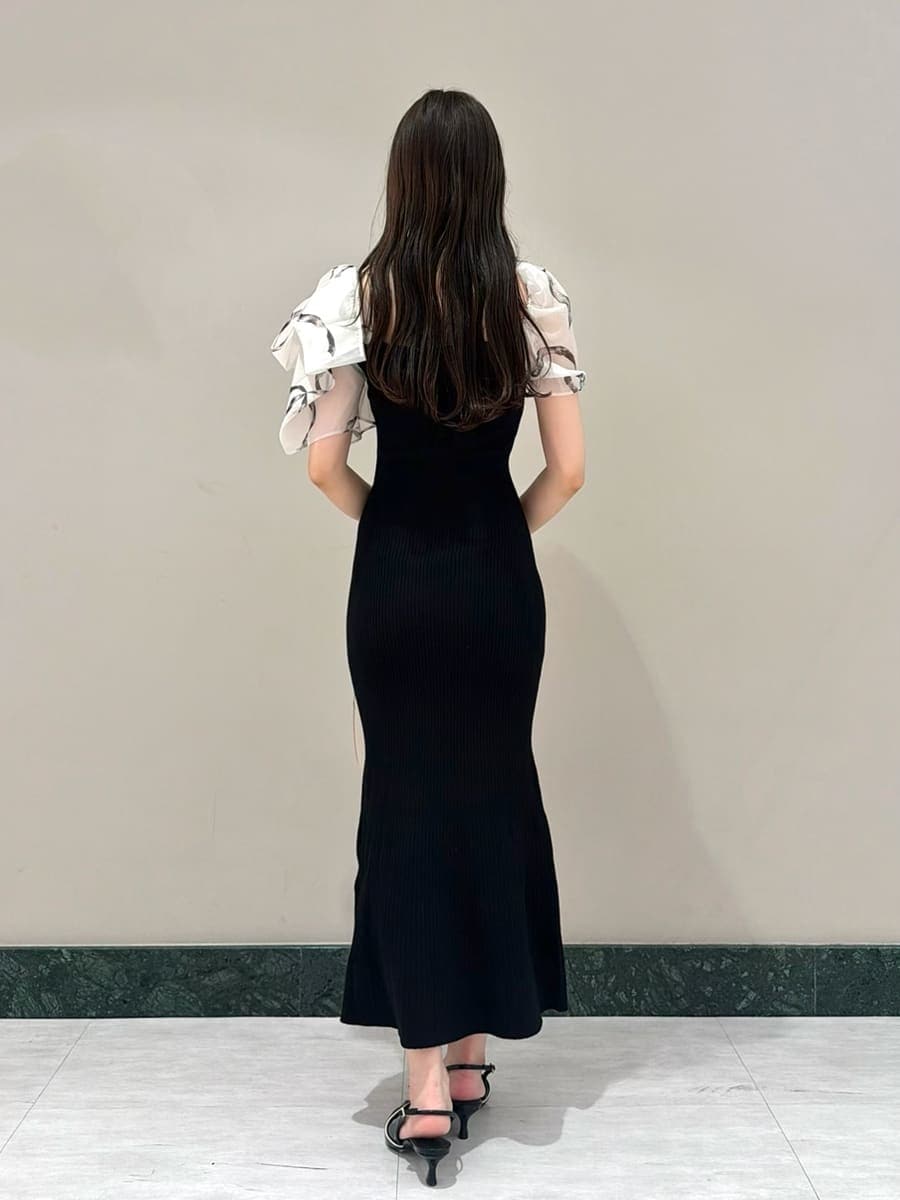 ブラック系のワンピース、ブラック系のパンプス、ベージュ系のハンドバッグを着用したレディースの春コーディネートの3枚目の写真