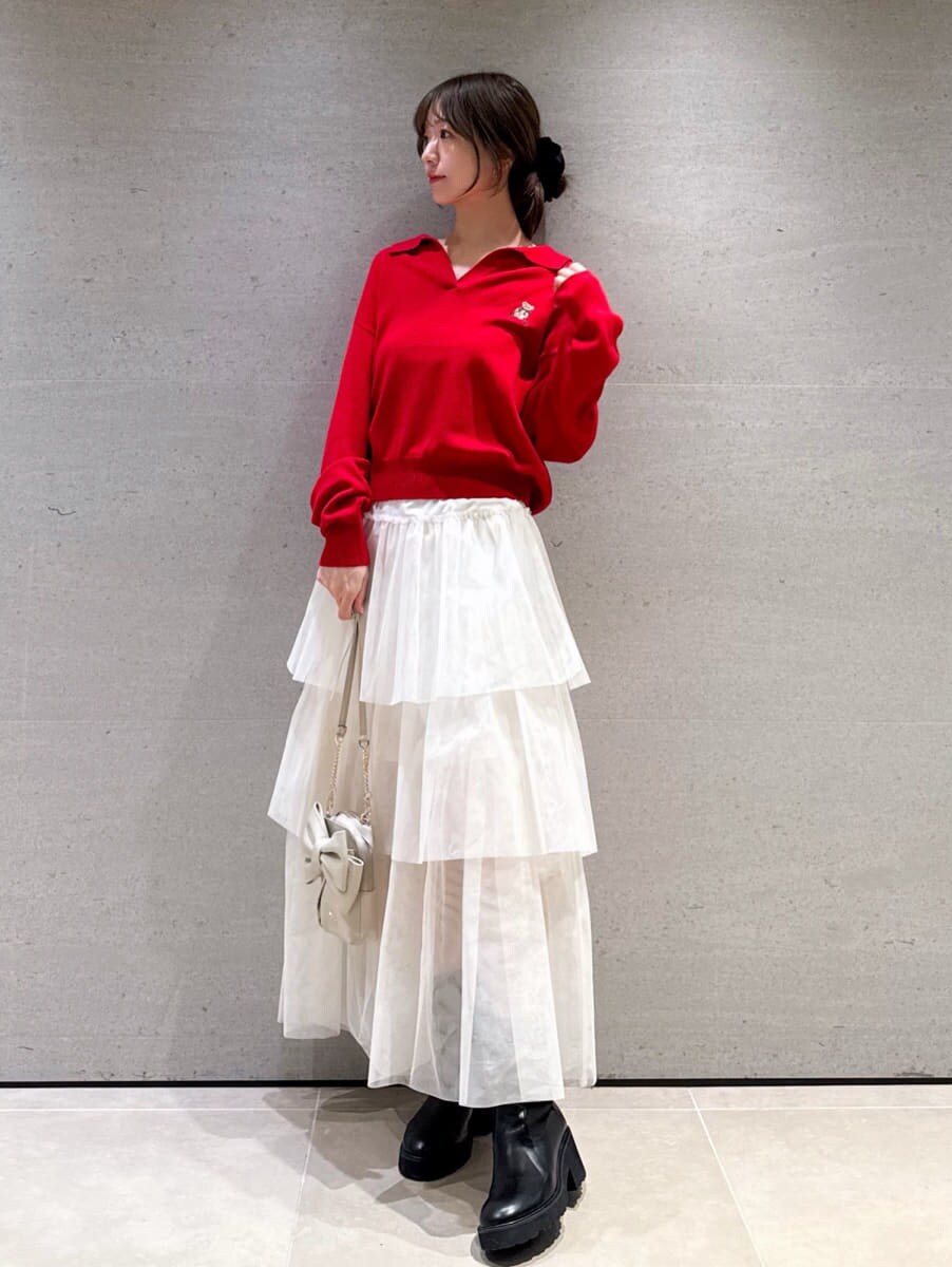 ホワイト系のスカート、レッド系のニット/セーター、ホワイト系のショルダーバッグを着用したレディースの秋コーディネートの2枚目の写真