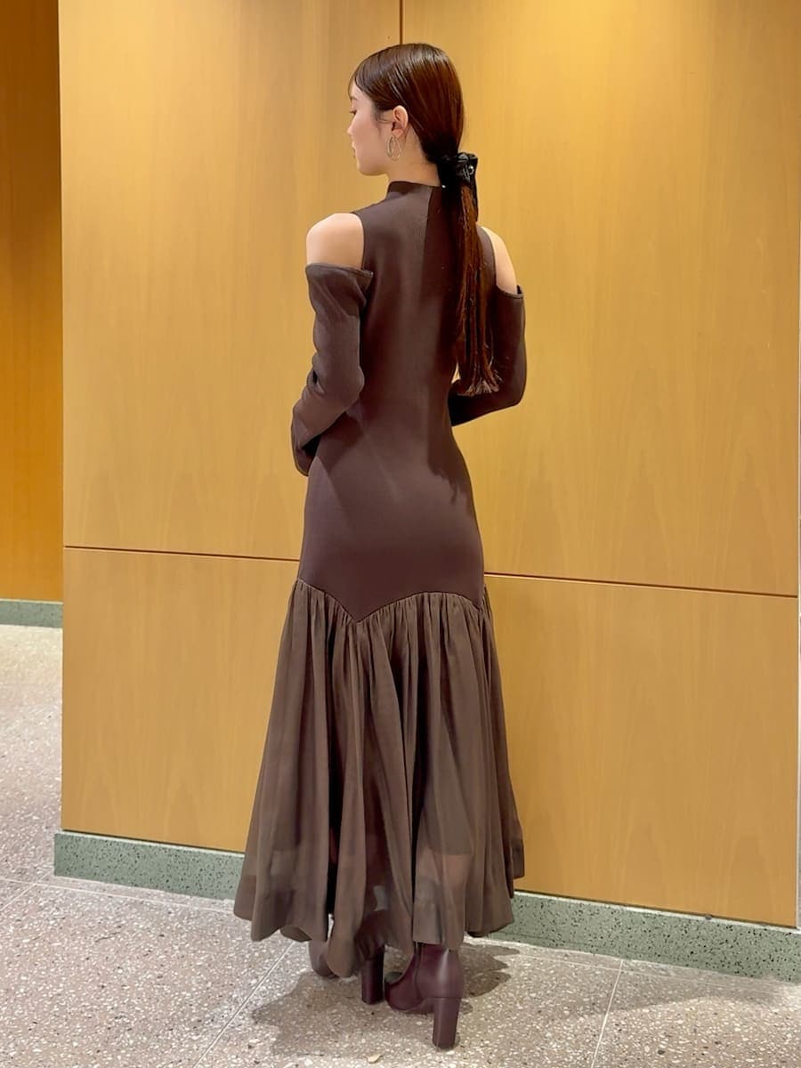 レッド系のブーツ、ブラウン系のワンピース、ブラウン系のハンドバッグを着用したレディースの秋コーディネートの3枚目の写真