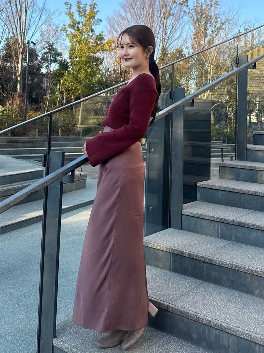 ブラウン系のステンカラーコートを着用したレディースの冬コーディネートの4枚目の写真