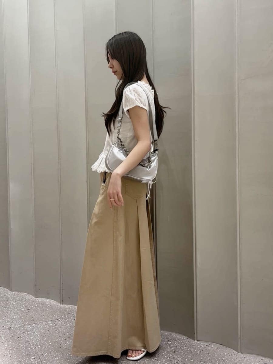 ベージュ系のスカート、ホワイト系のシャツ/ブラウス、シルバー系のショルダーバッグを着用したレディースの春コーディネートの3枚目の写真