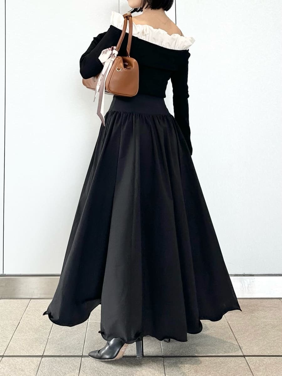 ブラック系のブーツ、ブラック系のスカート、ブラック系のニット/セーターを着用したレディースの冬コーディネートの3枚目の写真