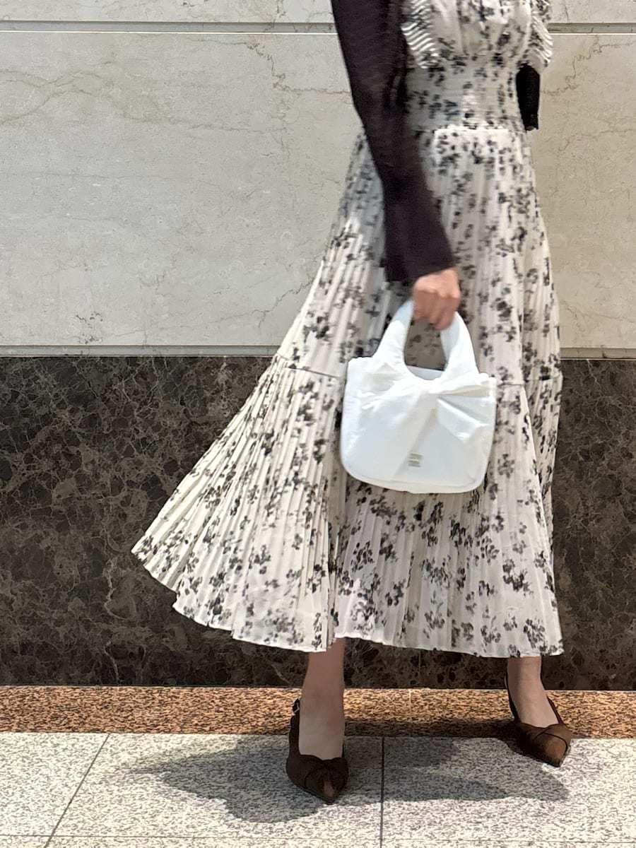 ベージュ系のワンピース、ホワイト系のカーディガン/ボレロ、ブラウン系のパンプスを着用したレディースの冬コーディネートの7枚目の写真