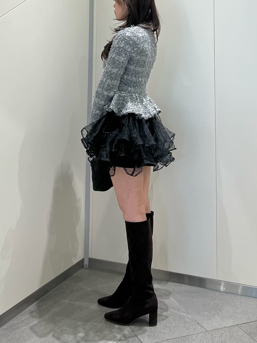 グレー系のワンピース、ブラウン系のブーツ、ブラック系のショルダーバッグを着用したレディースの秋コーディネートの3枚目の写真