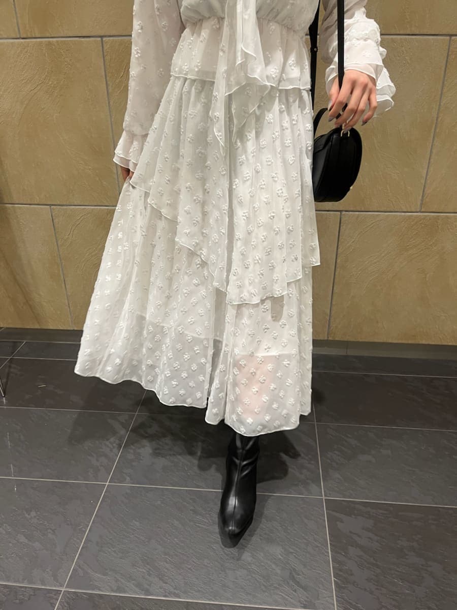 ブラック系のブーツ、ブラック系のハンドバッグ、シルバー系のスカートを着用したレディースの冬コーディネートの8枚目の写真