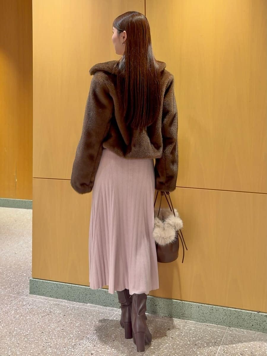 レッド系のブーツ、ブラウン系のステンカラーコート、ピンク系のワンピースを着用したレディースの秋コーディネートの3枚目の写真