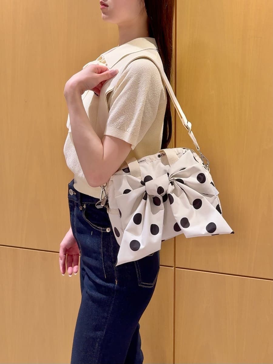 ブルー系のデニムパンツ、ホワイト系のショルダーバッグを着用したレディースの春コーディネートの5枚目の写真