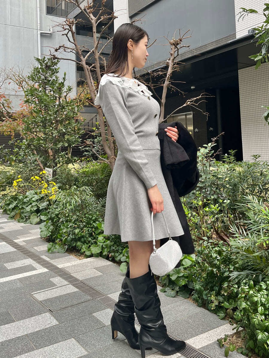 ブラック系のチェスターコート、グレー系のワンピースを着用したレディースの冬コーディネートの8枚目の写真