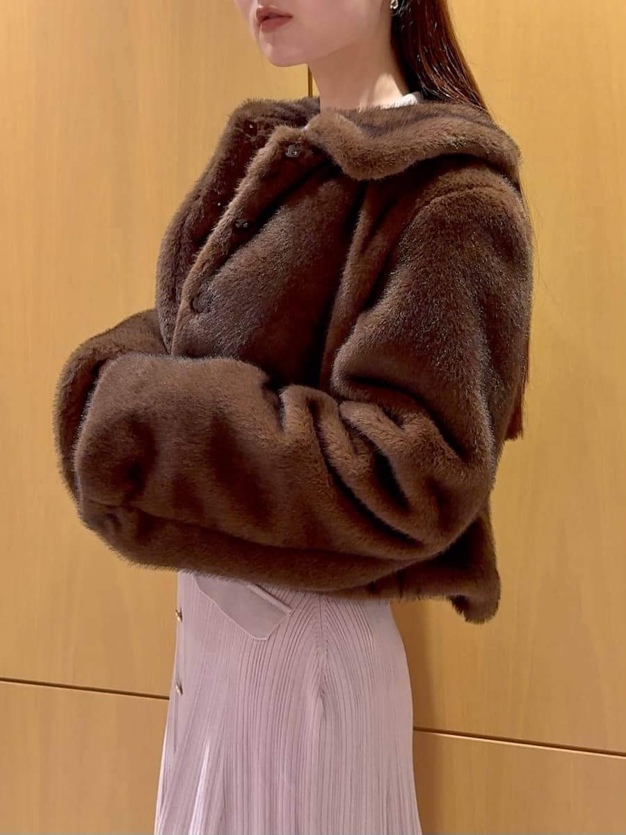 レッド系のブーツ、ブラウン系のステンカラーコート、ピンク系のワンピースを着用したレディースの秋コーディネートの7枚目の写真