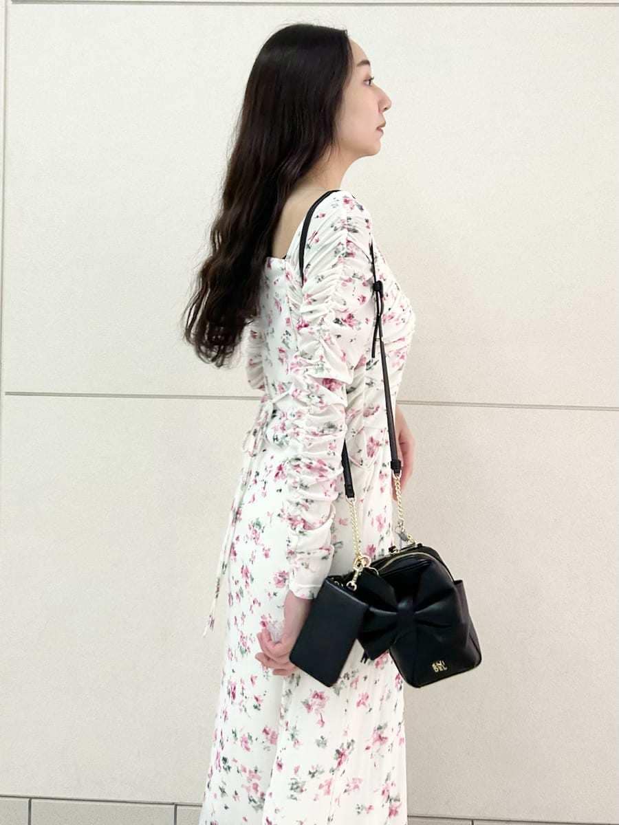 ブラック系のブーツ、ピンク系のワンピース、ブラック系のショルダーバッグを着用したレディースの冬コーディネートの6枚目の写真