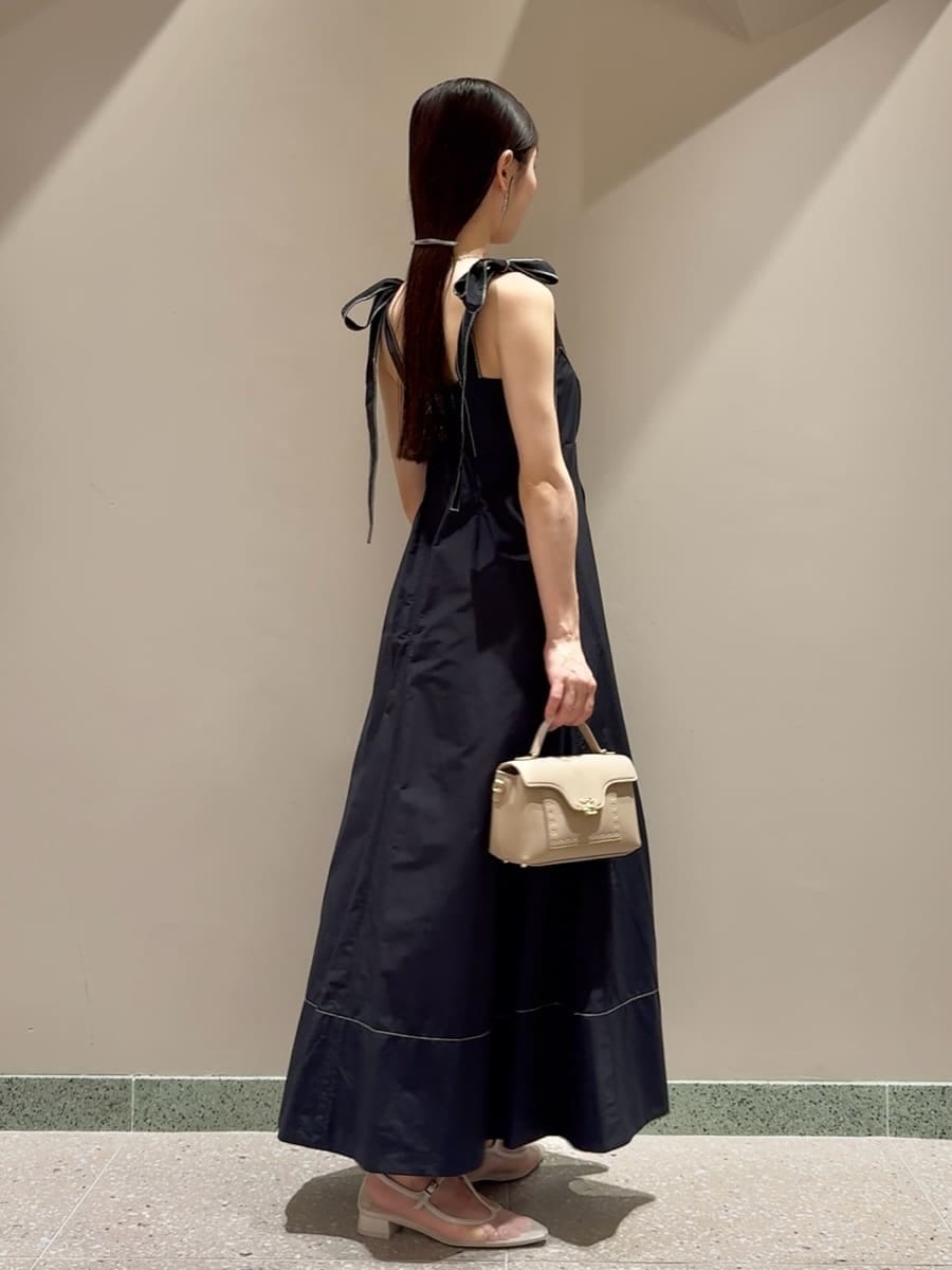 ブラック系のワンピース、ベージュ系のショルダーバッグ、シルバー系のネックレスを着用したレディースの夏コーディネートの3枚目の写真