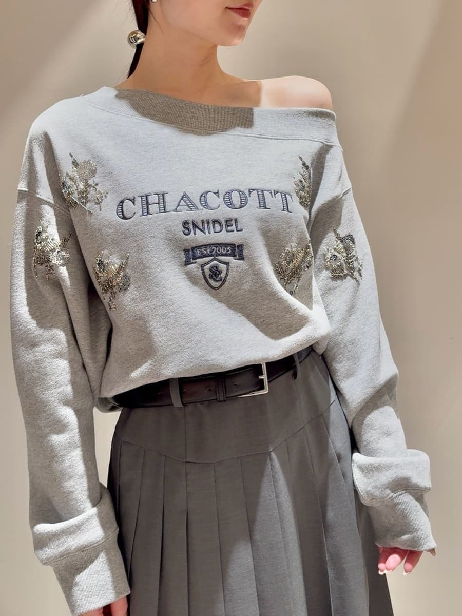 グレー系のスウェット、グレー系のスカート、ブラック系のローファーを着用したレディースの秋コーディネートの4枚目の写真