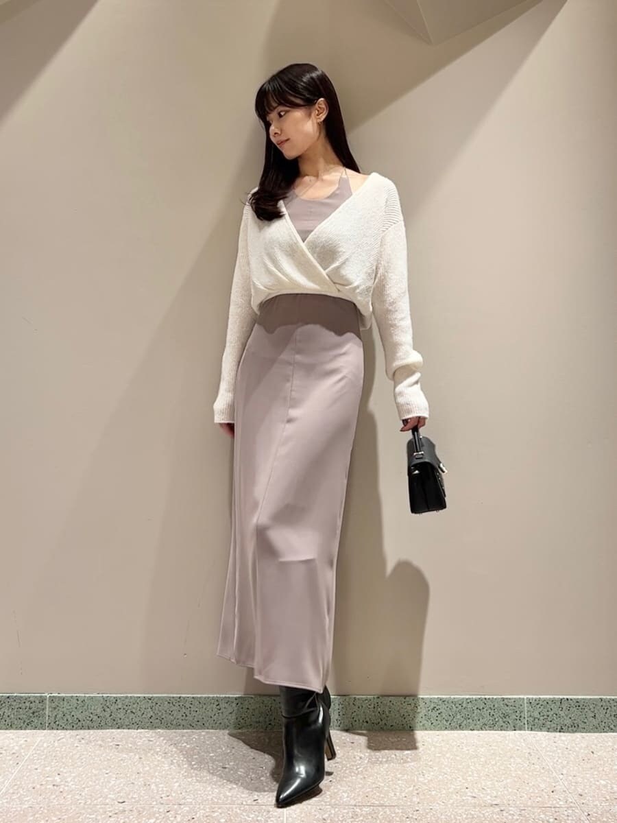 ホワイト系のワンピース、ブラック系のショルダーバッグ、ブラック系のブーツを着用したレディースの秋コーディネートの2枚目の写真