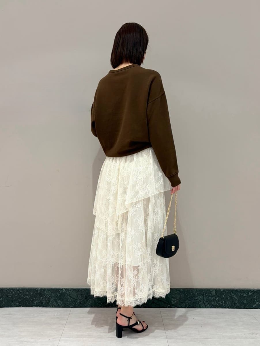 ホワイト系のスカート、ブラウン系のスウェット、ブラック系のショルダーバッグを着用したレディースの春コーディネートの2枚目の写真