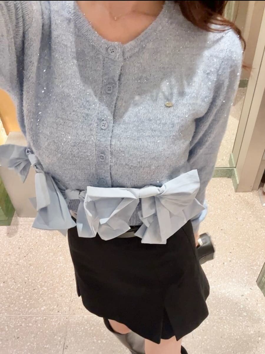 ブルー系のニット/セーター、ブラック系のスカート、ブラック系のショルダーバッグを着用したレディースの秋コーディネートの6枚目の写真