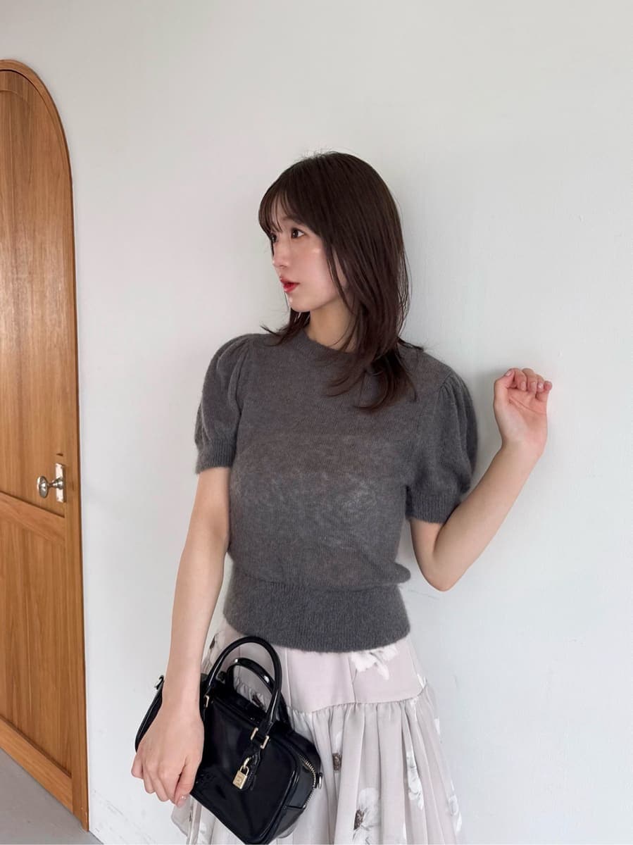 グレー系のニット/セーター、ブラック系のボストンバッグ、グレー系のブーツを着用したレディースの夏コーディネートの4枚目の写真