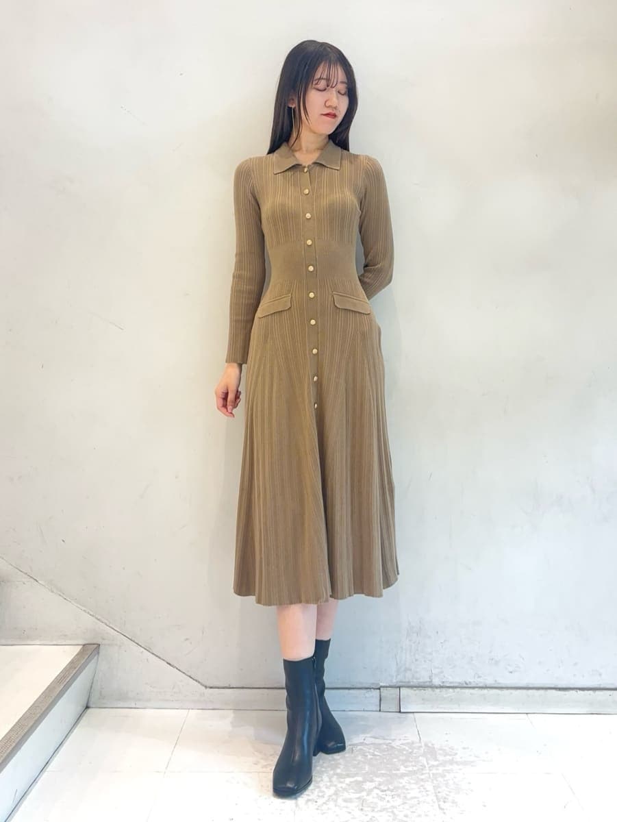 ホワイト系のチェスターコート、ベージュ系のワンピース、ホワイト系のボストンバッグを着用したレディースの秋コーディネートの3枚目の写真