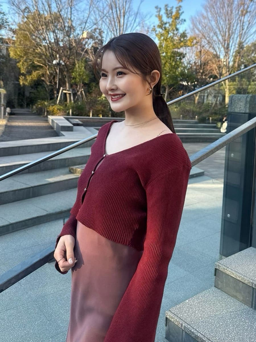 ブラウン系のステンカラーコートを着用したレディースの冬コーディネートの6枚目の写真