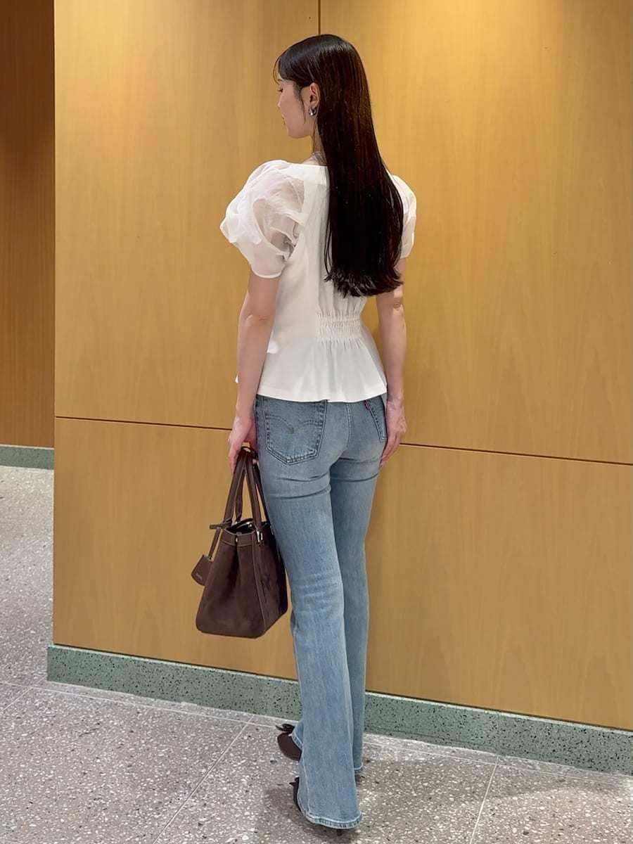 ブルー系のデニムパンツ、ホワイト系のTシャツ/カットソー、ブラウン系のハンドバッグを着用したレディースの夏コーディネートの3枚目の写真
