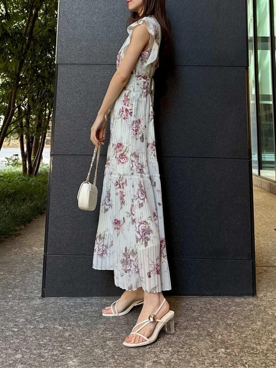 グリーン系のワンピース、ホワイト系のショルダーバッグ、ゴールド系のイヤリングを着用したレディースの春コーディネートの2枚目の写真