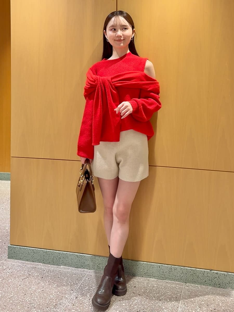 ホワイト系のその他パンツ、レッド系のニット/セーター、ブラウン系のハンドバッグを着用したレディースの冬コーディネートの2枚目の写真