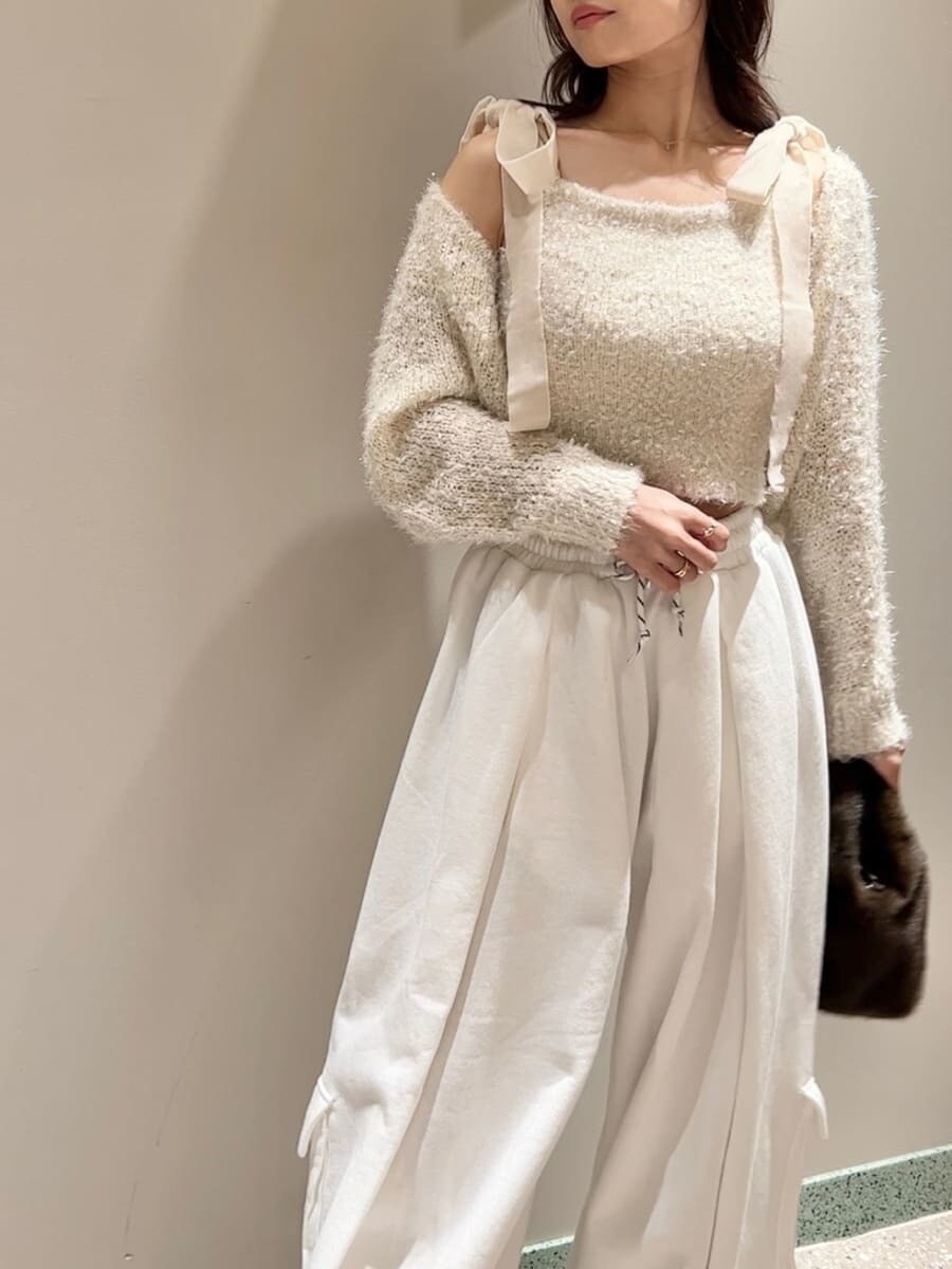 レッド系のブーツ、ホワイト系のニット/セーター、ホワイト系のスウェットパンツを着用したレディースの冬コーディネートの4枚目の写真