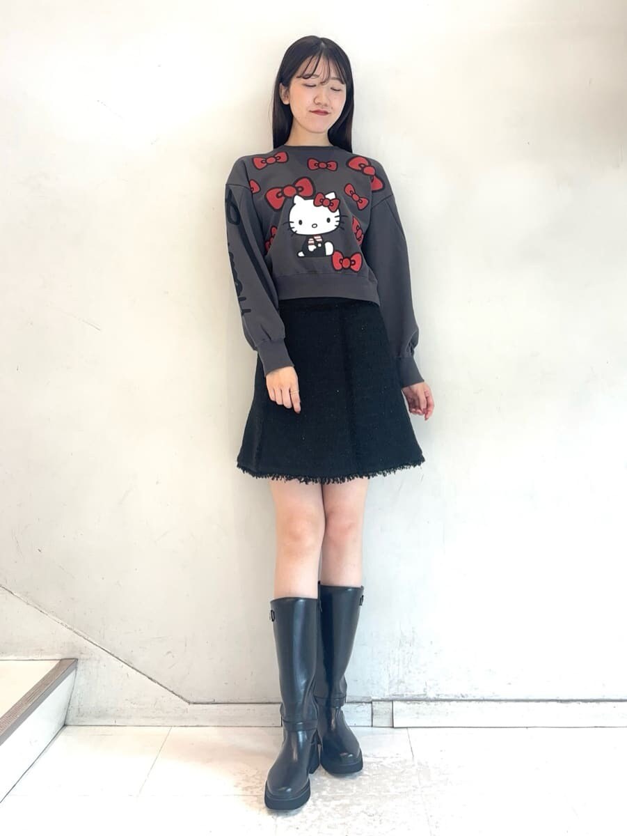 ブラック系のスウェット、ブラック系のスカート、ブラウン系のハンドバッグを着用したレディースの秋コーディネートの6枚目の写真