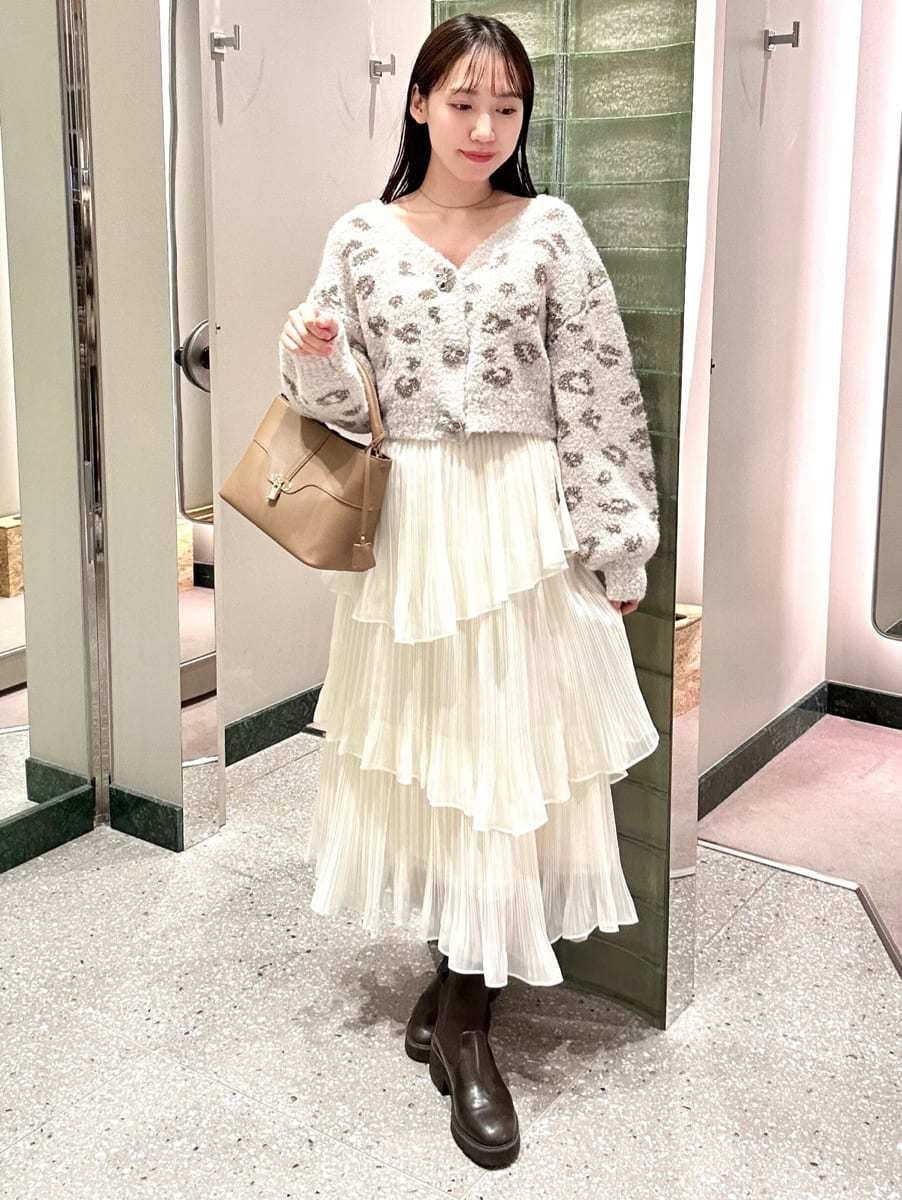 グレー系のダウンジャケット/コート、ホワイト系のスカート、その他のカーディガン/ボレロを着用したレディースの秋コーディネートの2枚目の写真
