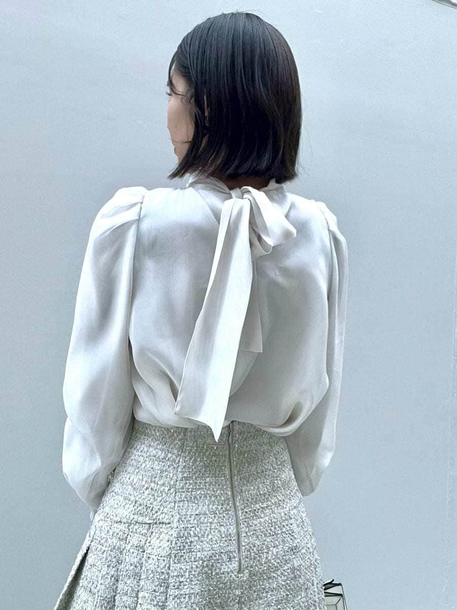 ホワイト系のスカート、ブラック系のブーツ、ブラック系のダウンジャケット/コートを着用したレディースの冬コーディネートの9枚目の写真