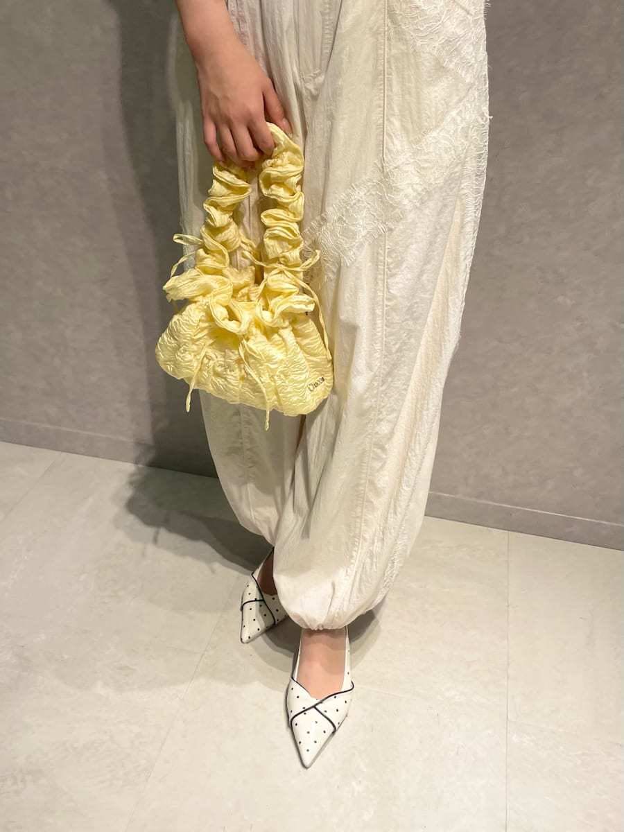 ホワイト系のその他パンツ、イエロー系のカーディガン/ボレロ、その他のパンプスを着用したレディースの春コーディネートの6枚目の写真