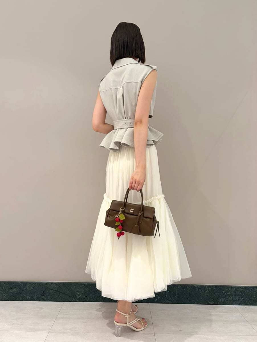 グレー系のワンピース、ホワイト系のサンダル、ブラウン系のボストンバッグを着用したレディースの夏コーディネートの3枚目の写真