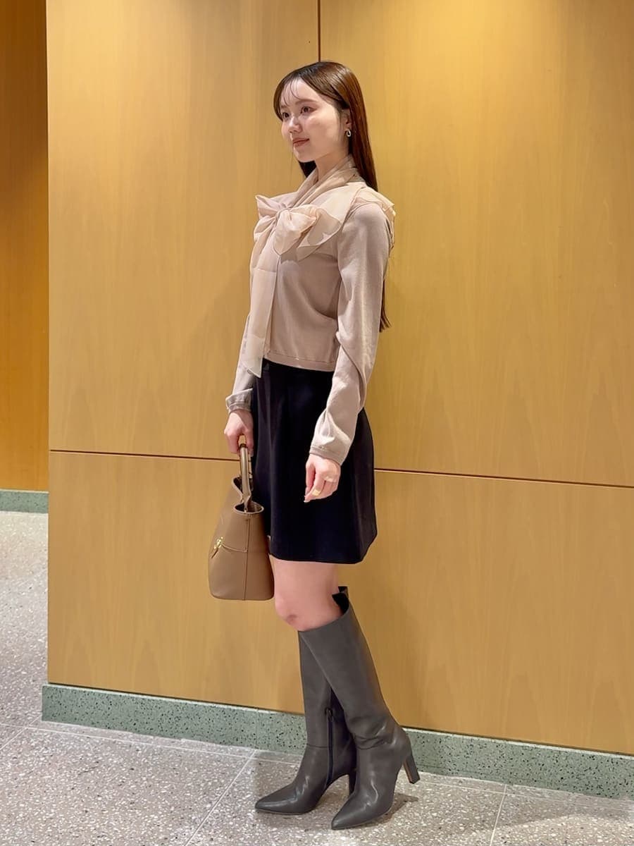 グレー系のブーツ、ピンク系のニット/セーター、ブラック系のスカートを着用したレディースの冬コーディネートの3枚目の写真