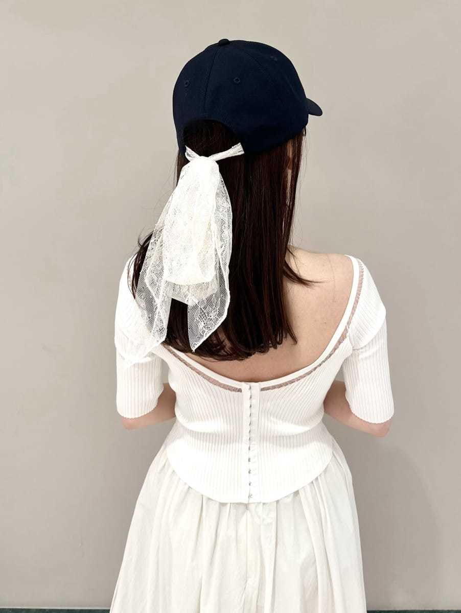 ブラック系のスニーカー、ブルー系のキャップを着用したレディースの春コーディネートの6枚目の写真