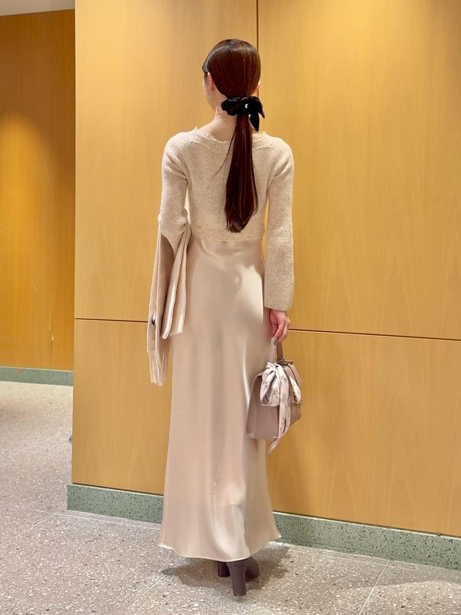 レッド系のブーツ、ピンク系のハンドバッグ、ピンク系のワンピースを着用したレディースの秋コーディネートの3枚目の写真