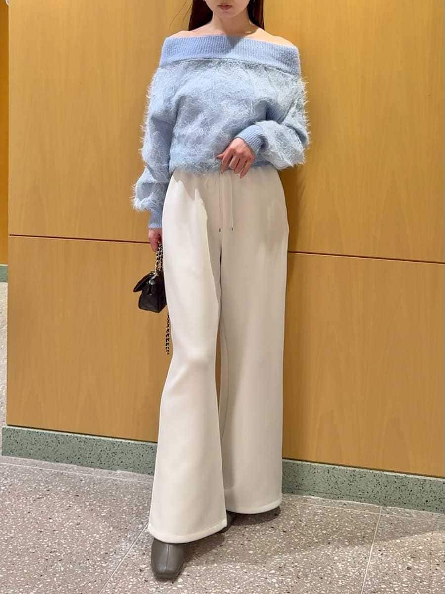 ブラック系のショルダーバッグ、ホワイト系のスウェットパンツ、ブルー系のニット/セーターを着用したレディースの冬コーディネートの6枚目の写真