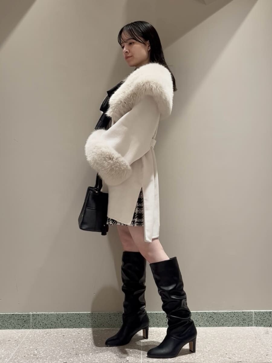 ホワイト系のチェスターコート、ブラック系のその他パンツ、ブラック系のハンドバッグを着用したレディースの冬コーディネートの2枚目の写真