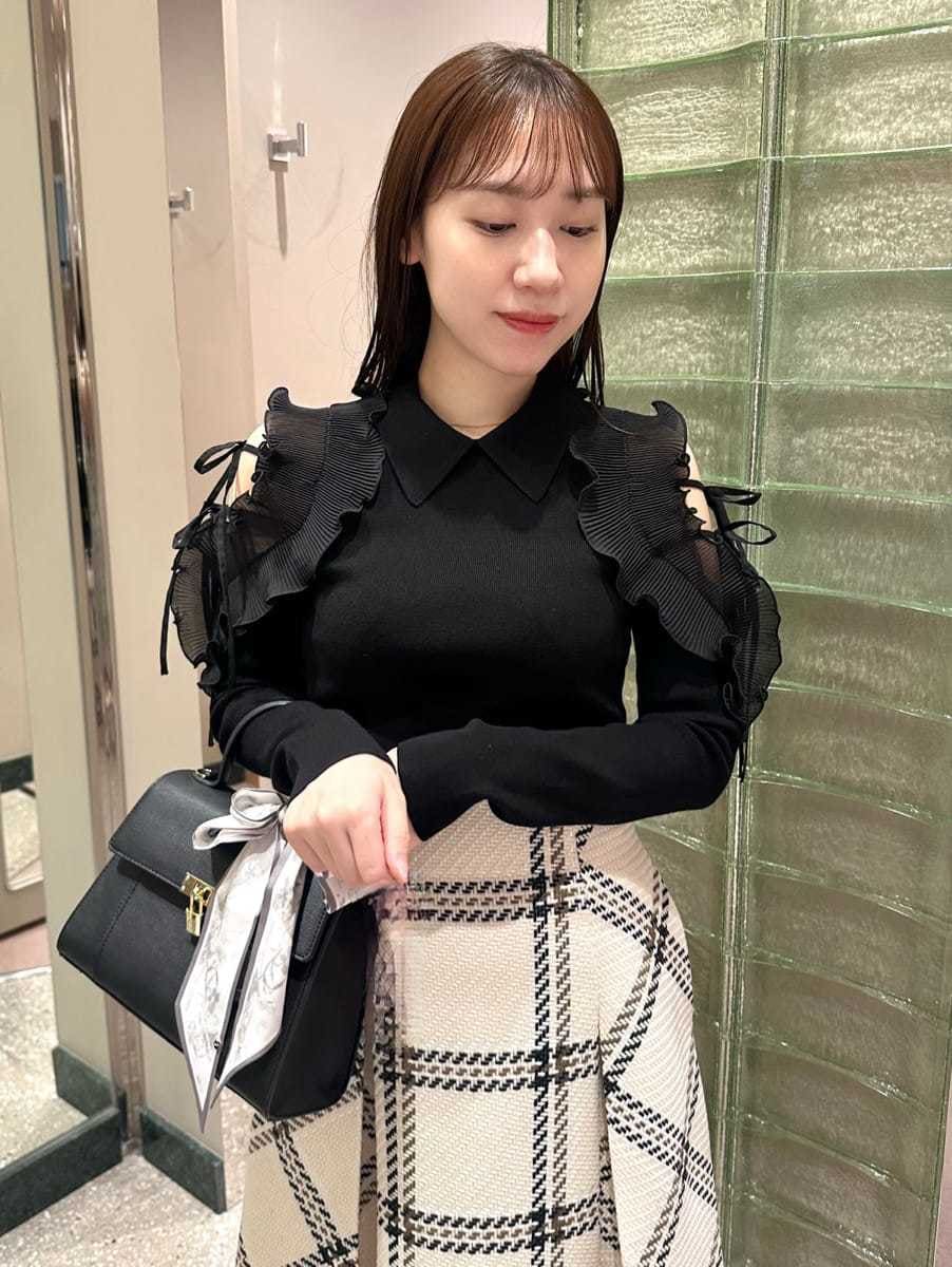 ブラック系のニット/セーター、ホワイト系のスカート、レッド系のブーツを着用したレディースの秋コーディネートの2枚目の写真