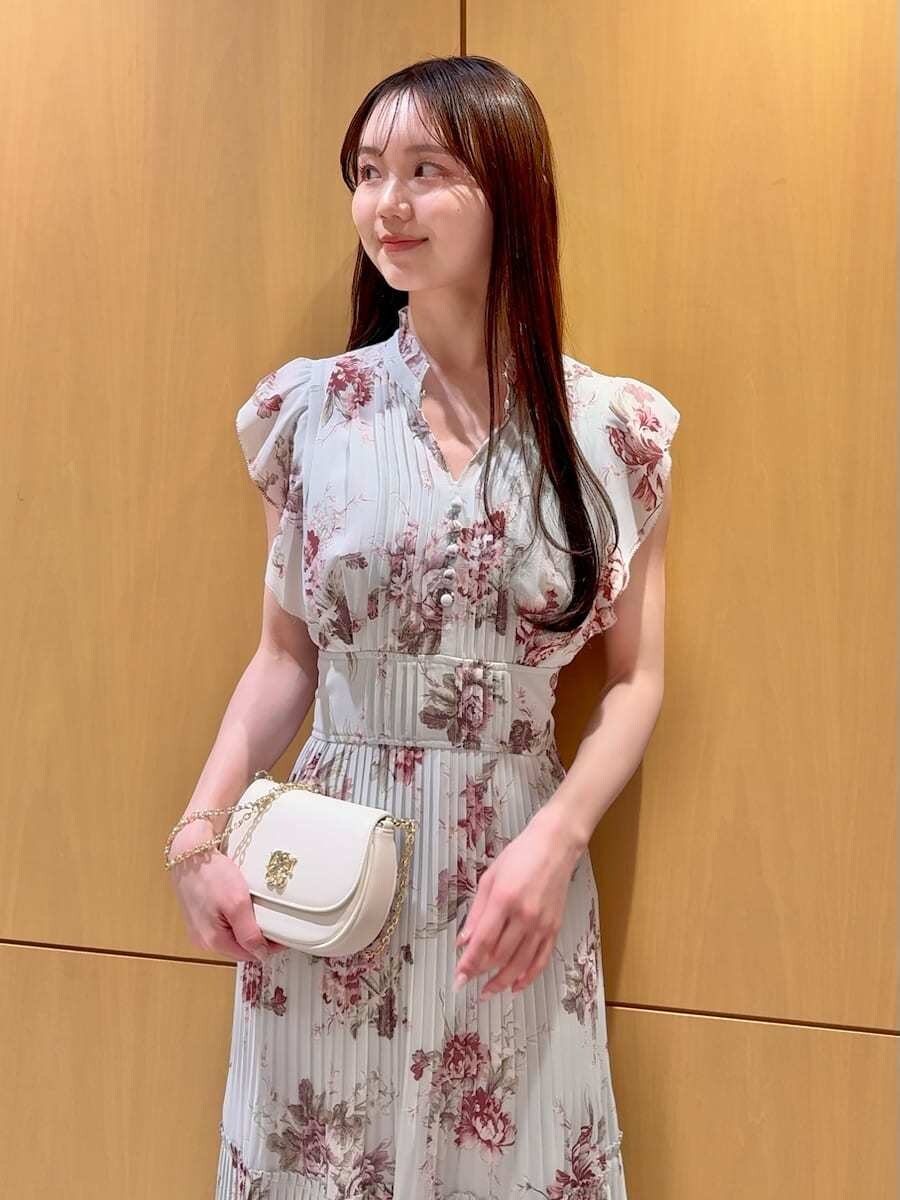 グリーン系のワンピース、ブラウン系のパンプス、ホワイト系のショルダーバッグを着用したレディースの春コーディネートの7枚目の写真