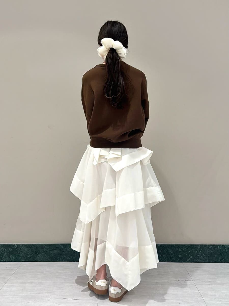 ホワイト系のスカート、ブラウン系のスウェット、イエロー系のボストンバッグを着用したレディースの春コーディネートの3枚目の写真