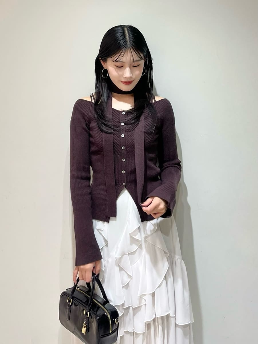 ブラウン系のニット/セーター、ホワイト系のスカート、ブラック系のボストンバッグを着用したレディースの秋コーディネートの4枚目の写真